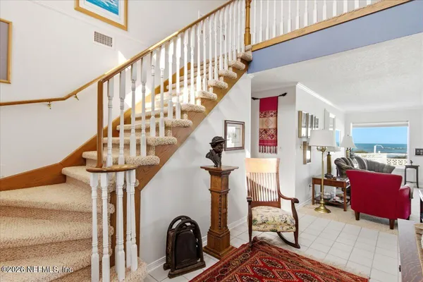 a living room with furniture kitchen view and a chandelier