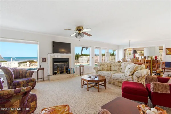 a living room with furniture kitchen view and a chandelier