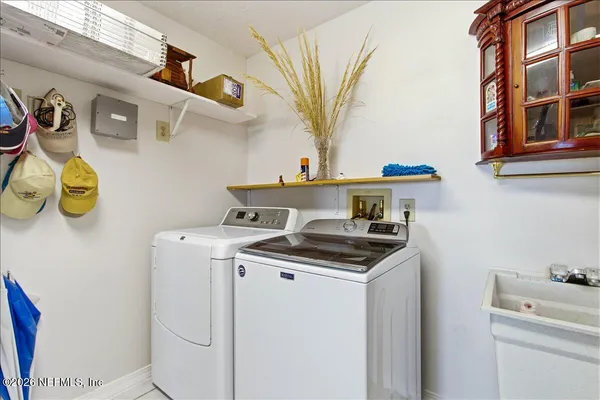 an aerial view of ocean and residential houses with outdoor space