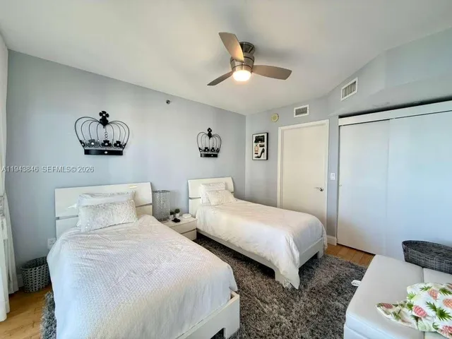a spacious bedroom with a bed and a flat screen tv