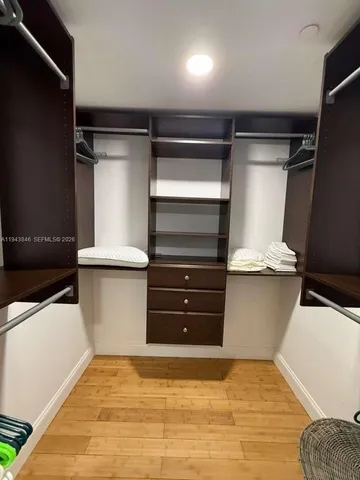 a room with stainless steel appliances kitchen island granite countertop a table chairs sink and cabinets