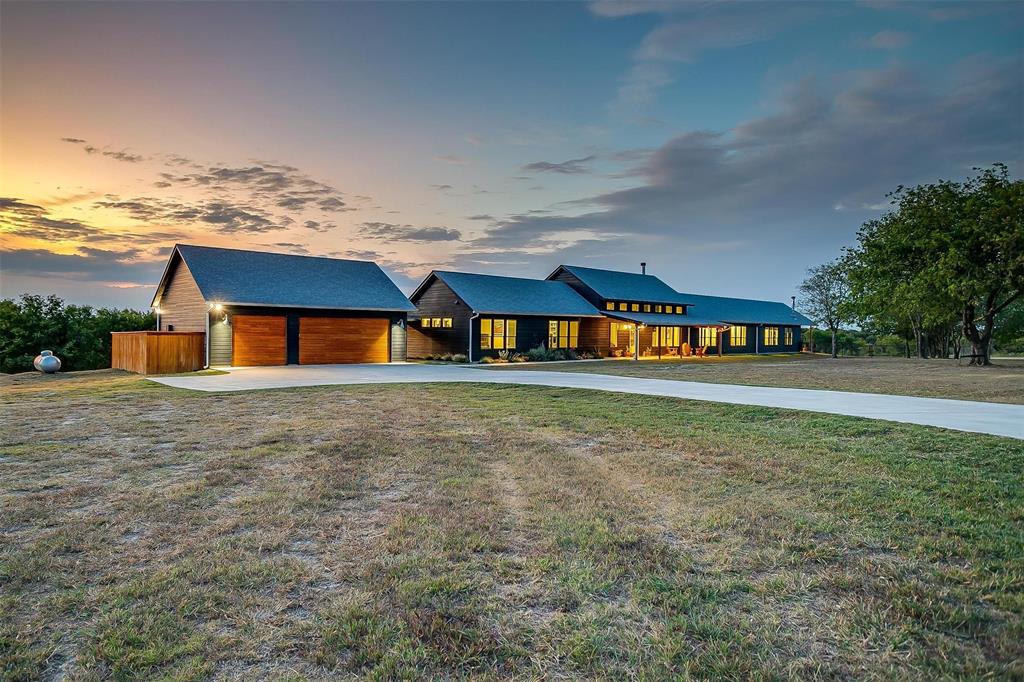 a front view of a house with large trees