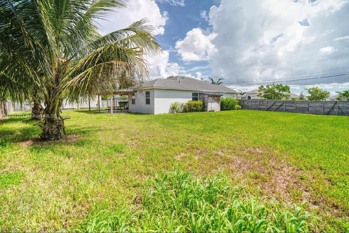 30600 Southwest 193rd Avenue Homestead, FL 33030 - Photo 24 of 36 a view of a house with a big yard and palm trees