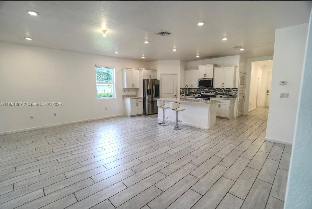 30600 Southwest 193rd Avenue Homestead, FL 33030 - Photo 28 of 36 a kitchen with stainless steel appliances granite countertop a stove a sink and a refrigerator