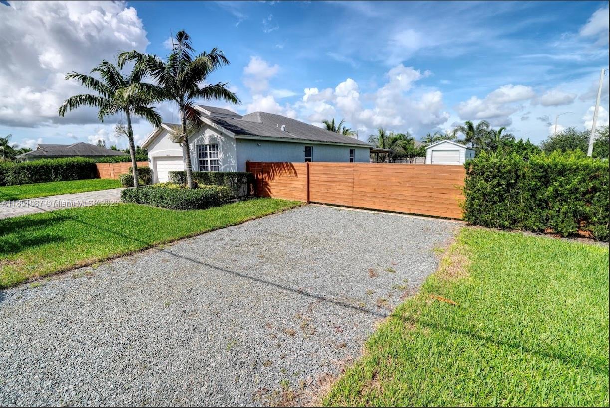 30600 Southwest 193rd Avenue Homestead, FL 33030 - Photo 3 of 36 a view of a house with a yard and potted plants
