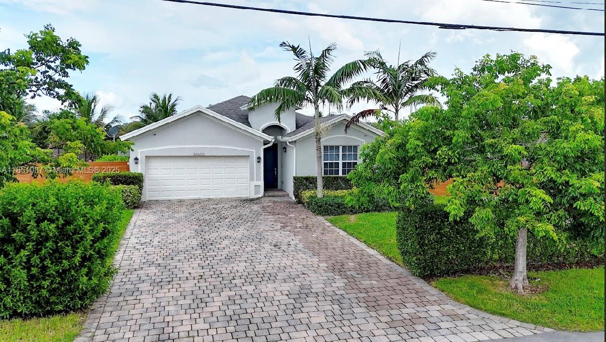 30600 Southwest 193rd Avenue Homestead, FL 33030 - Photo 35 of 36 a front view of a house with a yard and garage