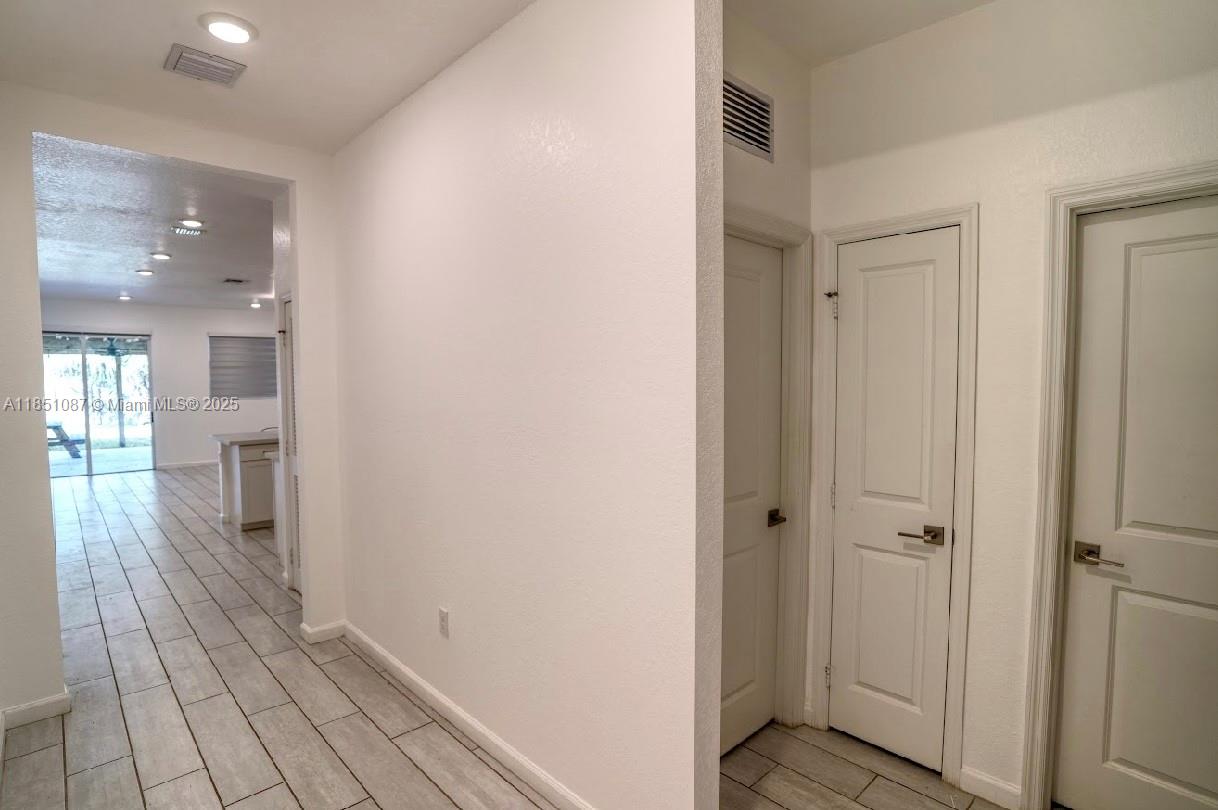 30600 Southwest 193rd Avenue Homestead, FL 33030 - Photo 4 of 36 a view of a hallway with wooden floor and a bathroom