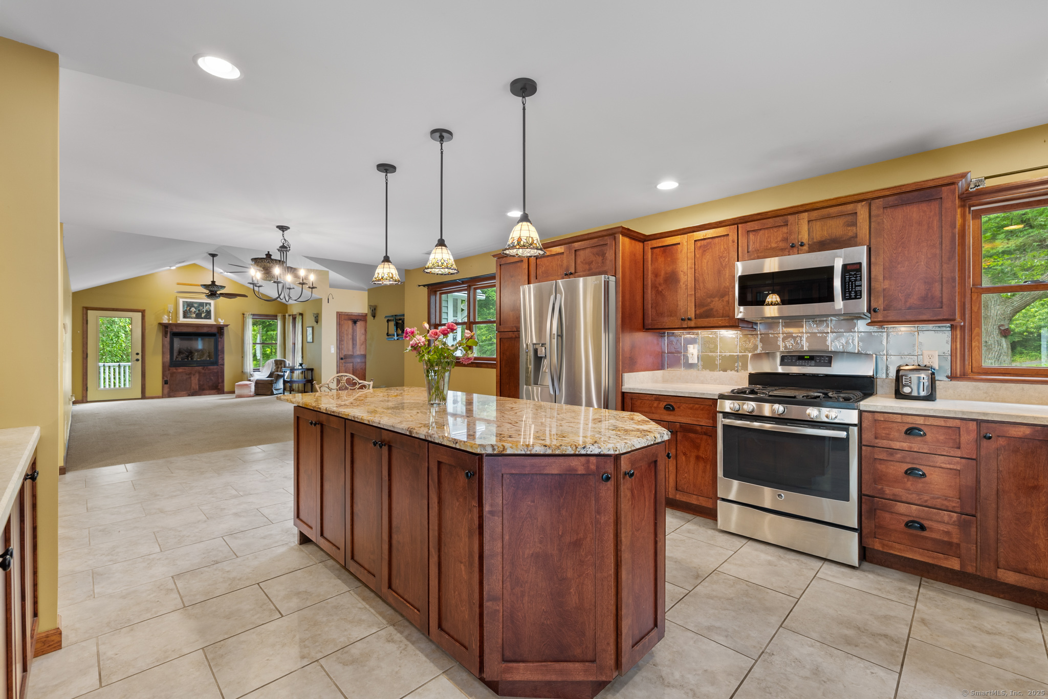 a kitchen with stainless steel appliances granite countertop a stove a sink and a refrigerator
