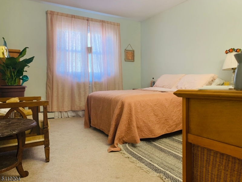 2467 Highway 10, Unit 5B Morris Plains, NJ 07950 - Photo 7 of 12 a bedroom with a bed and a table in it