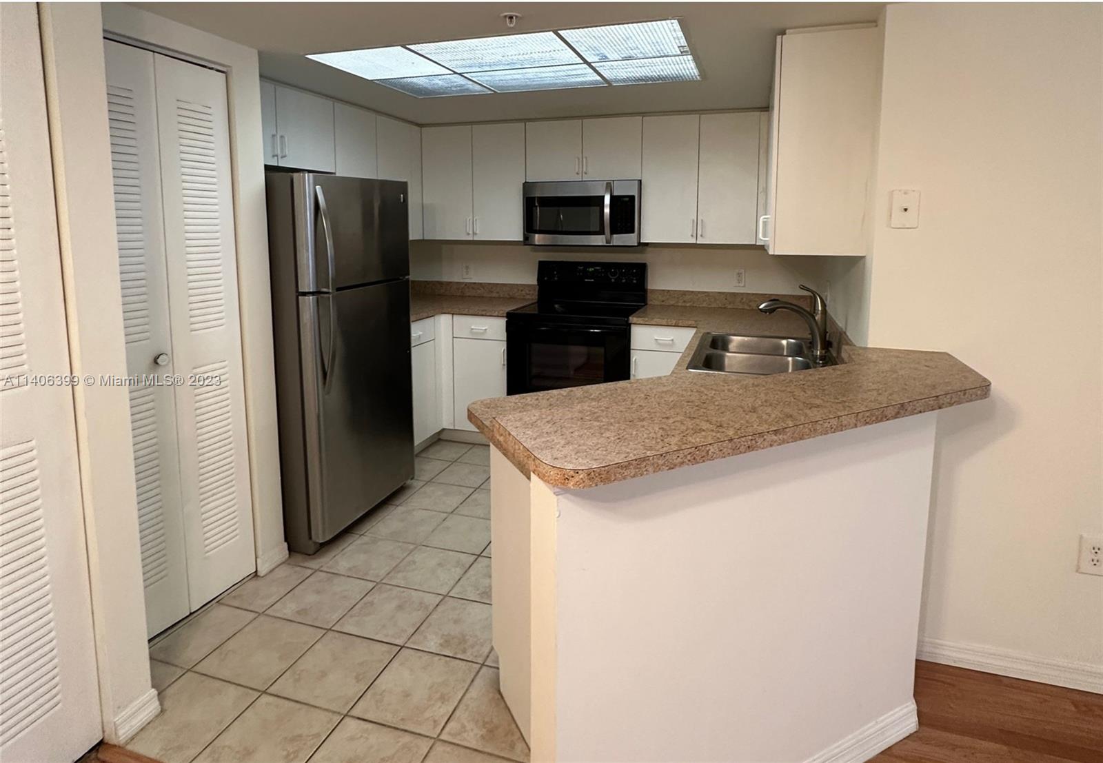 4155 Haverhill Road, Unit 1418 West Palm Beach, FL 33417 - Photo 11 of 13 a kitchen with stainless steel appliances granite countertop a refrigerator a stove a sink and a refrigerator