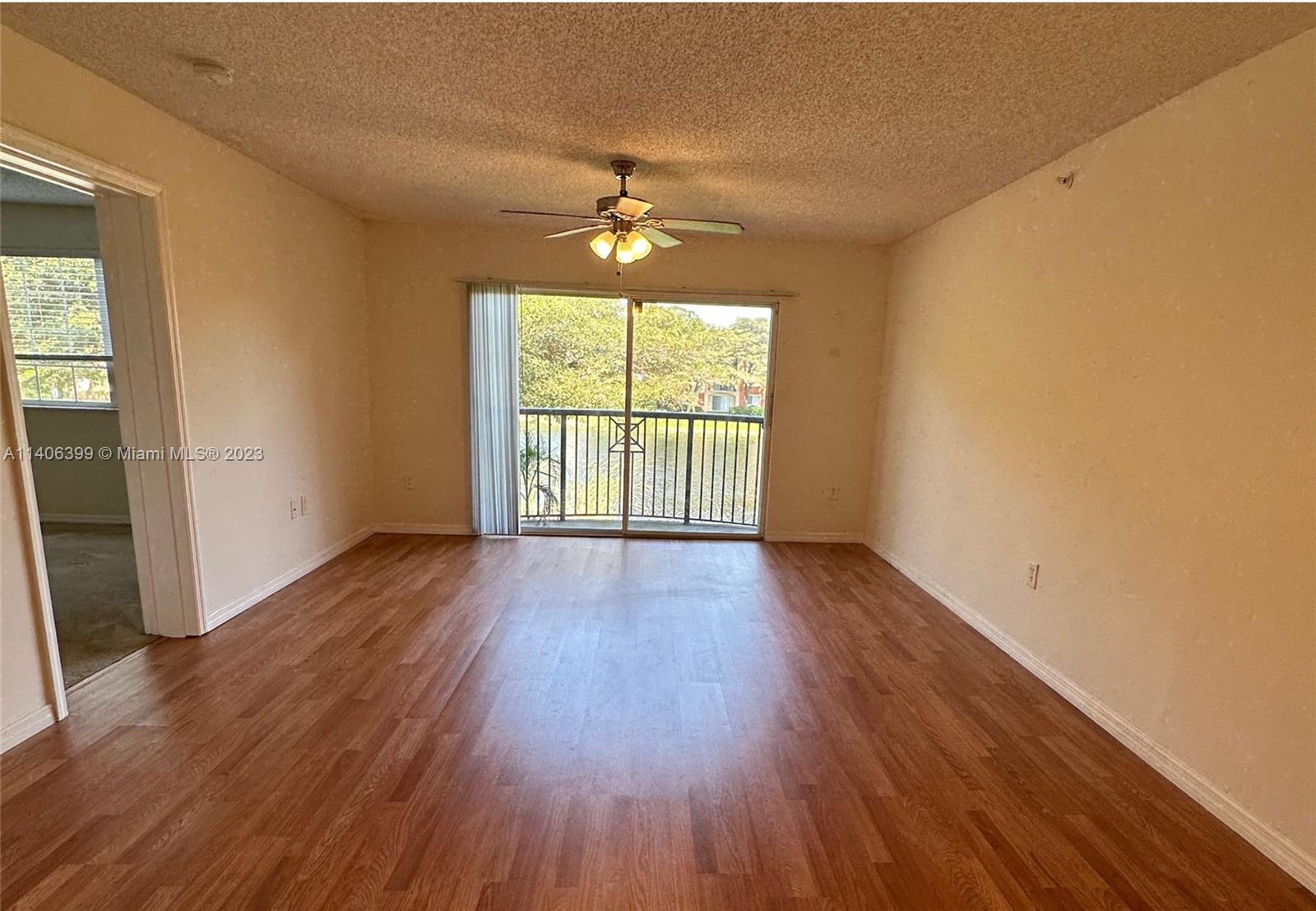 4155 Haverhill Road, Unit 1418 West Palm Beach, FL 33417 - Photo 9 of 13 an empty room with wooden floor and windows
