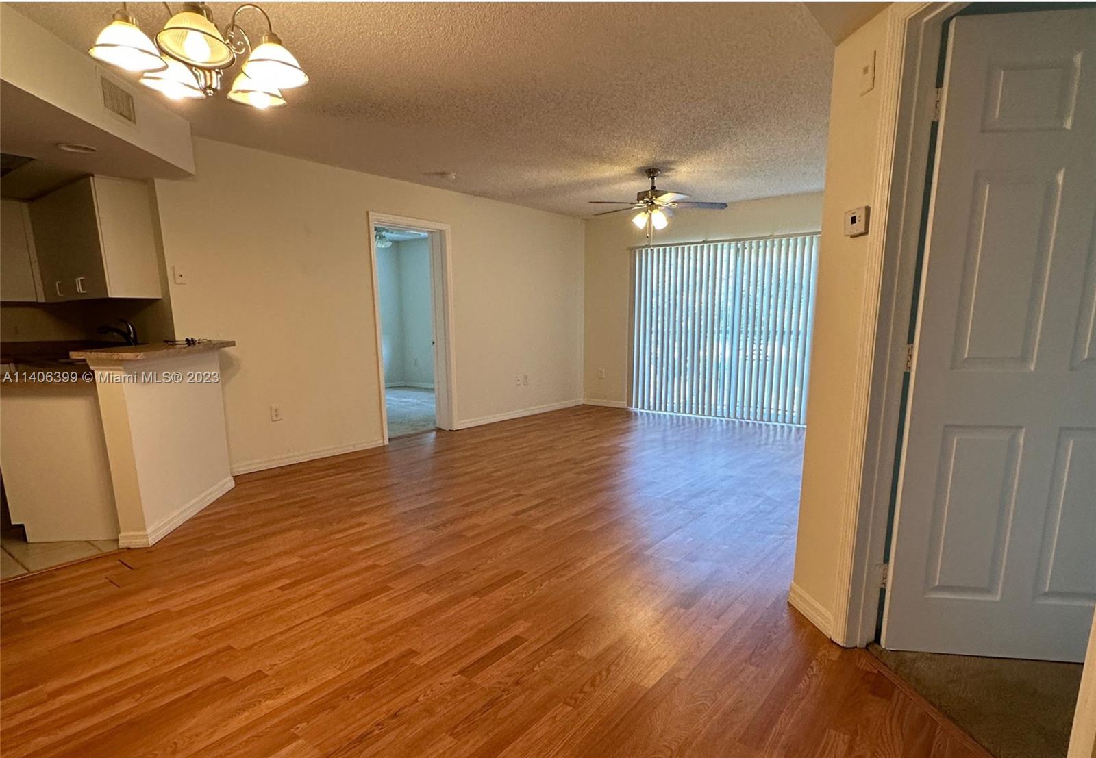 4155 Haverhill Road, Unit 1418 West Palm Beach, FL 33417 - Photo 10 of 13 a view of an empty room with wooden floor and a window