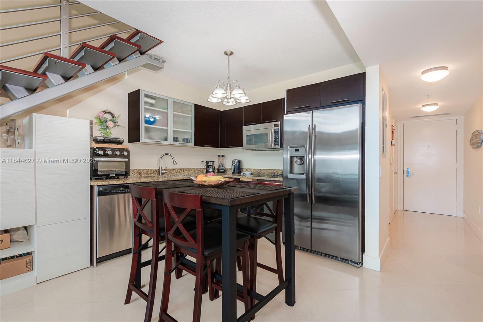 41 Southeast 5th Street, Unit 1503 Miami, FL 33131 - Photo 15 of 27 a kitchen with stainless steel appliances granite countertop a dining table and chairs