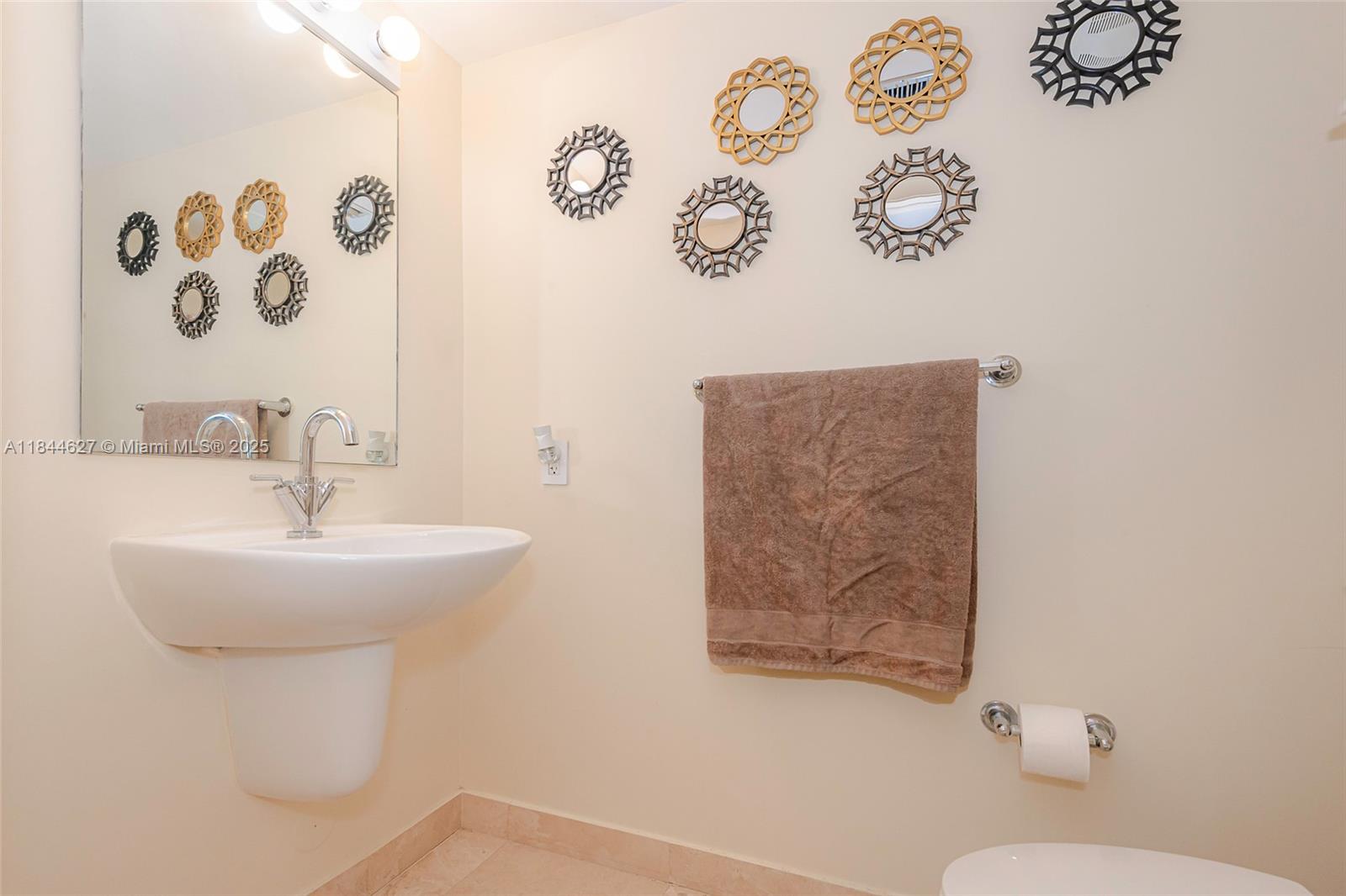 41 Southeast 5th Street, Unit 1503 Miami, FL 33131 - Photo 17 of 27 a bathroom with a sink and mirror with toilet