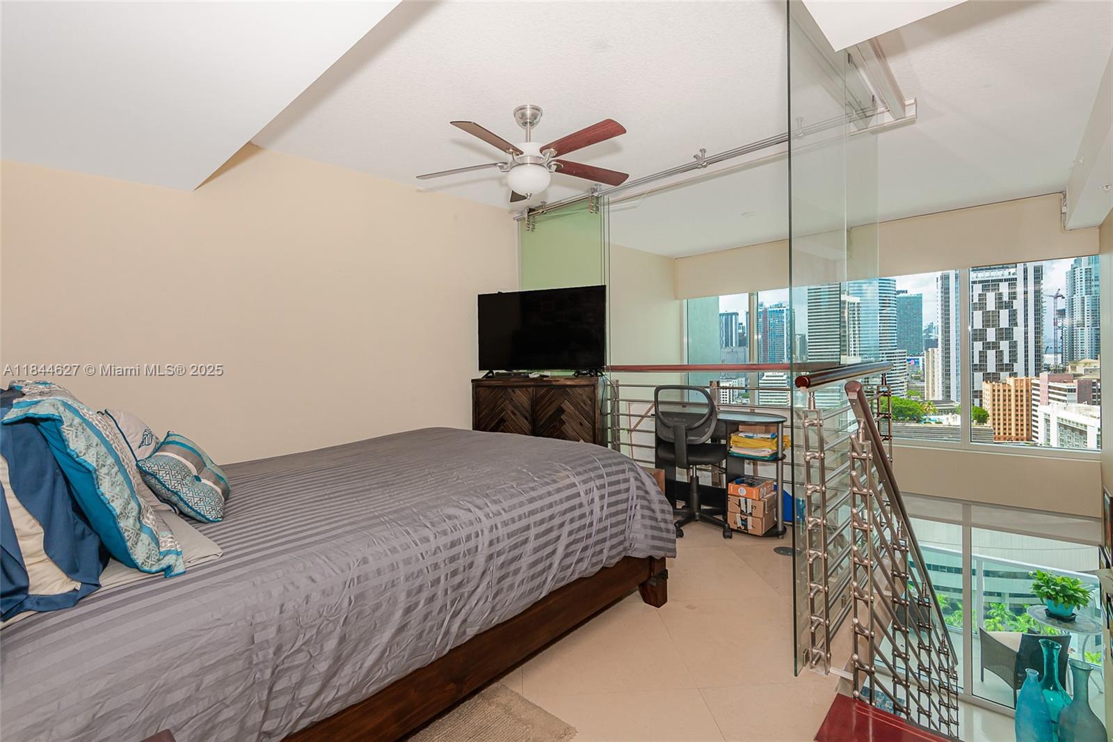 41 Southeast 5th Street, Unit 1503 Miami, FL 33131 - Photo 23 of 27 a bedroom with a bed and flat screen tv