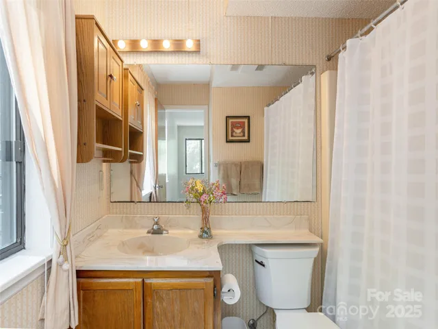 a bathroom with a granite countertop sink a mirror and a toilet