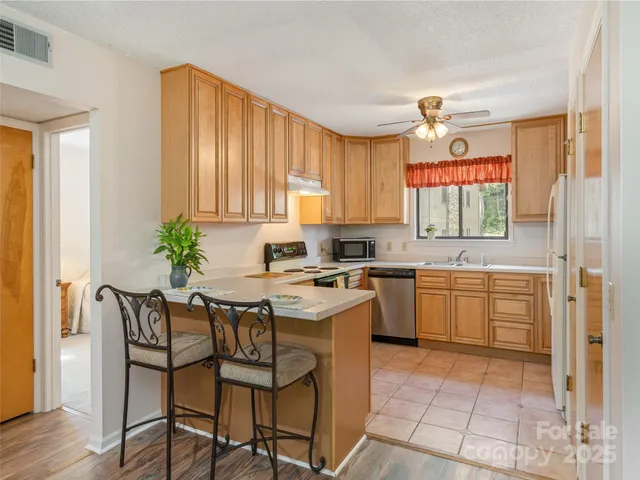 a kitchen with a stove a sink cabinets and a window