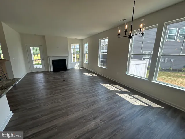 a view of empty room with wooden floor and fireplace