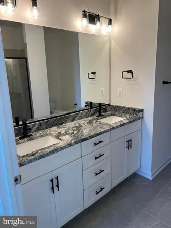 a bathroom with a granite countertop sink and a mirror