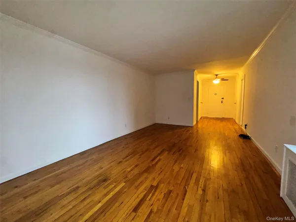 a view of a big room with wooden floor and windows