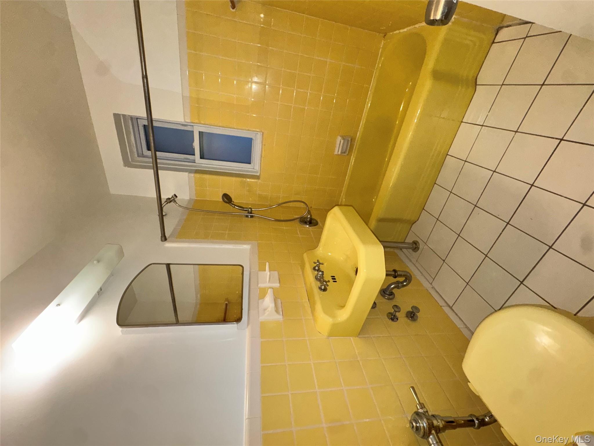 43 Bronx River Road, Unit 6C Yonkers, NY 10704 - Photo 5 of 12 a bathroom with a sink mirror toilet and shower