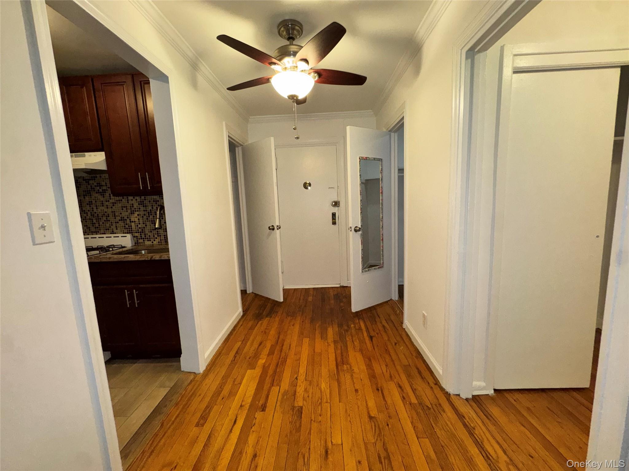 43 Bronx River Road, Unit 6C Yonkers, NY 10704 - Photo 6 of 12 a view of a hallway with wooden floor and a kitchen space