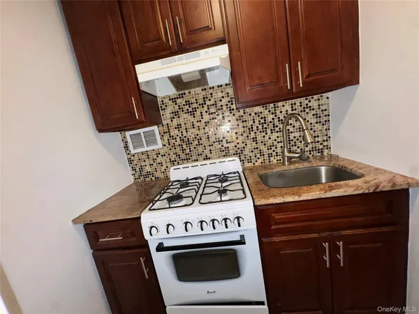 a stove top oven sitting inside of a kitchen