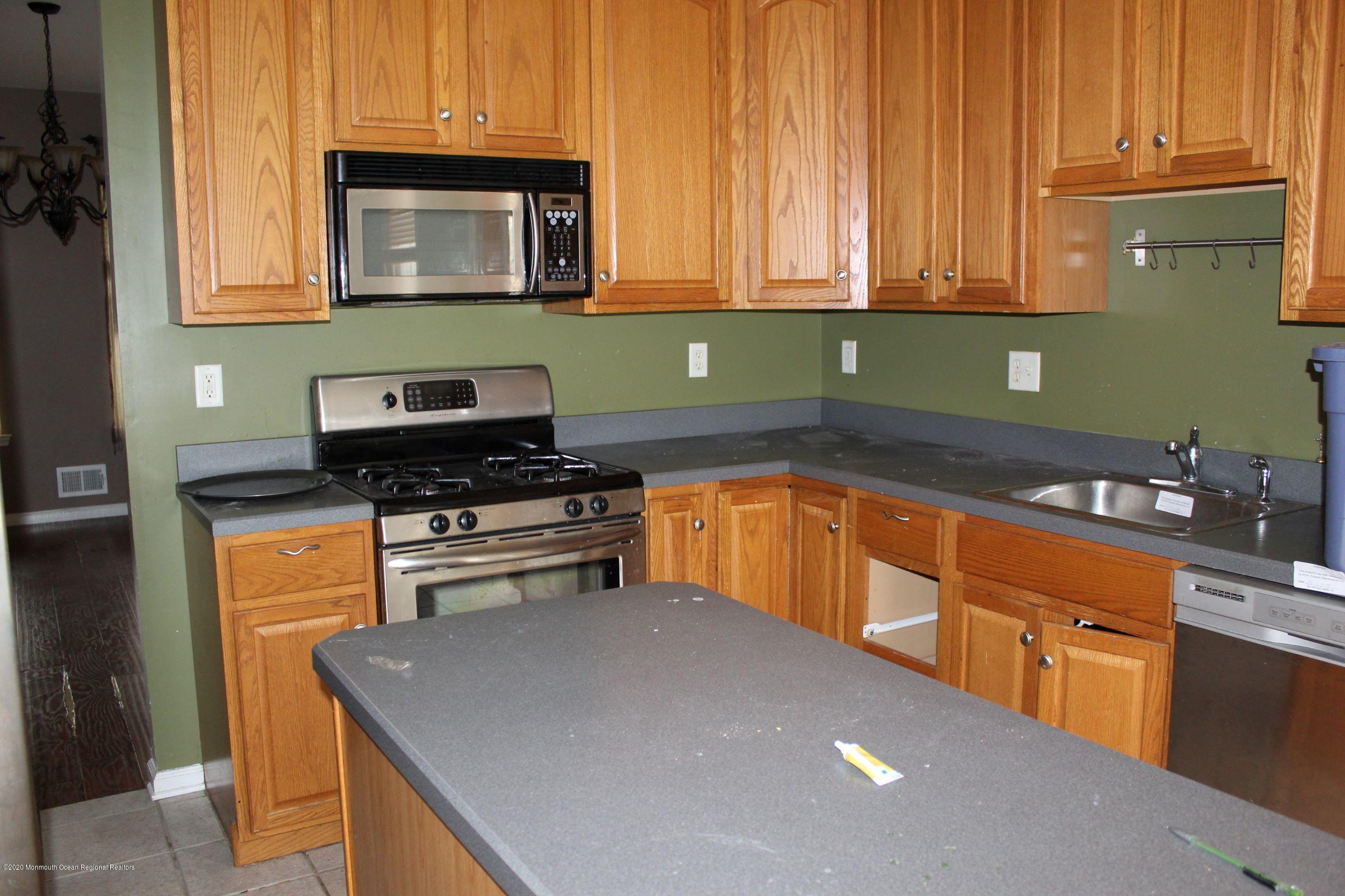211 Cassville Road Jackson, NJ 08527 - Photo 11 of 58 a kitchen with granite countertop a stove top oven microwave and cabinets
