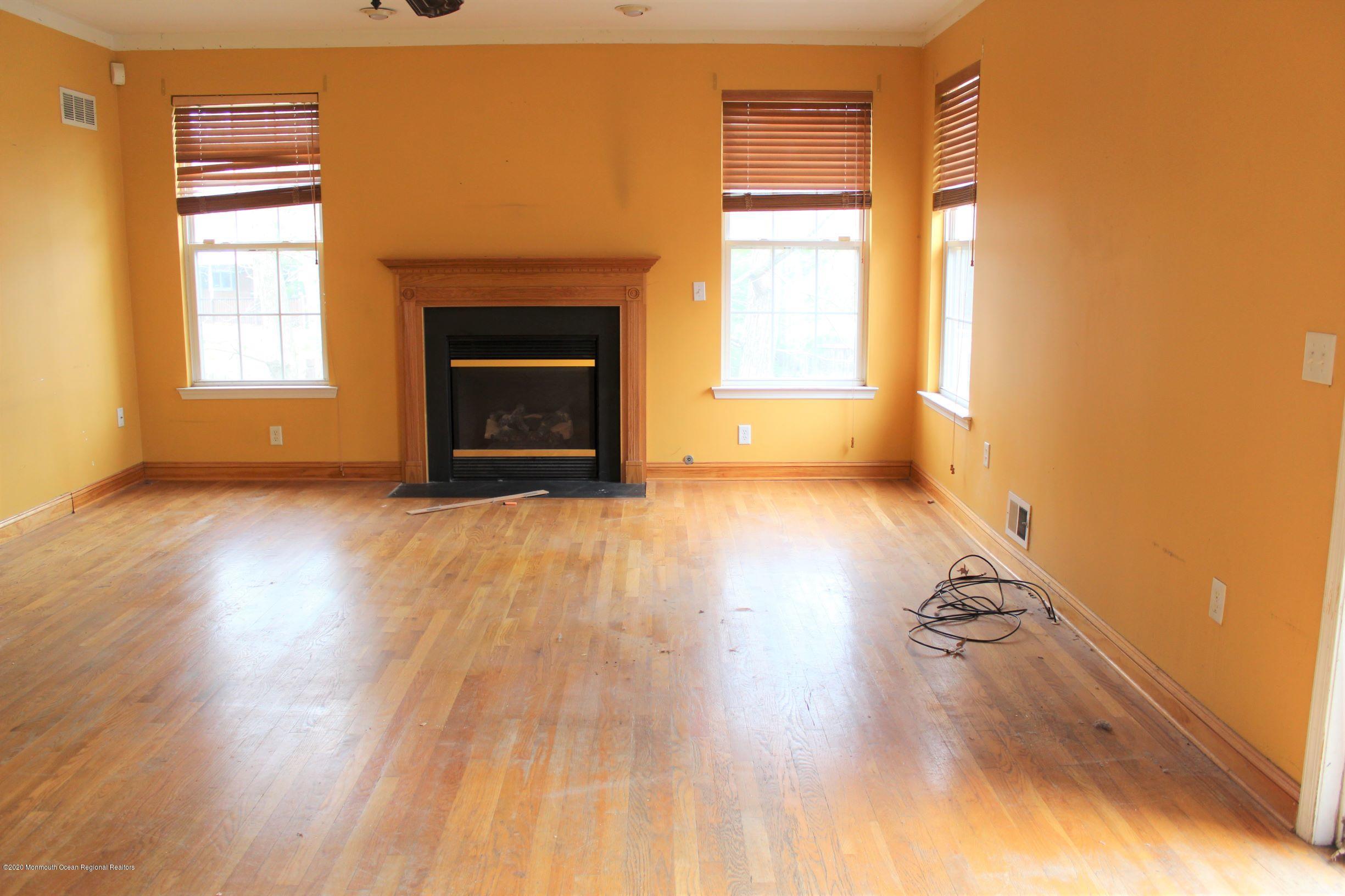 211 Cassville Road Jackson, NJ 08527 - Photo 18 of 58 a view of empty room with wooden floor and fireplace
