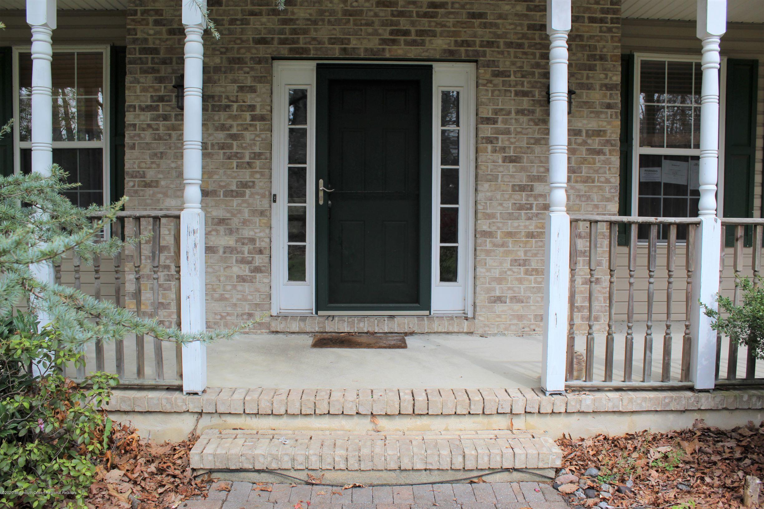 211 Cassville Road Jackson, NJ 08527 - Photo 4 of 58 front view of a brick house with a bench in front of door