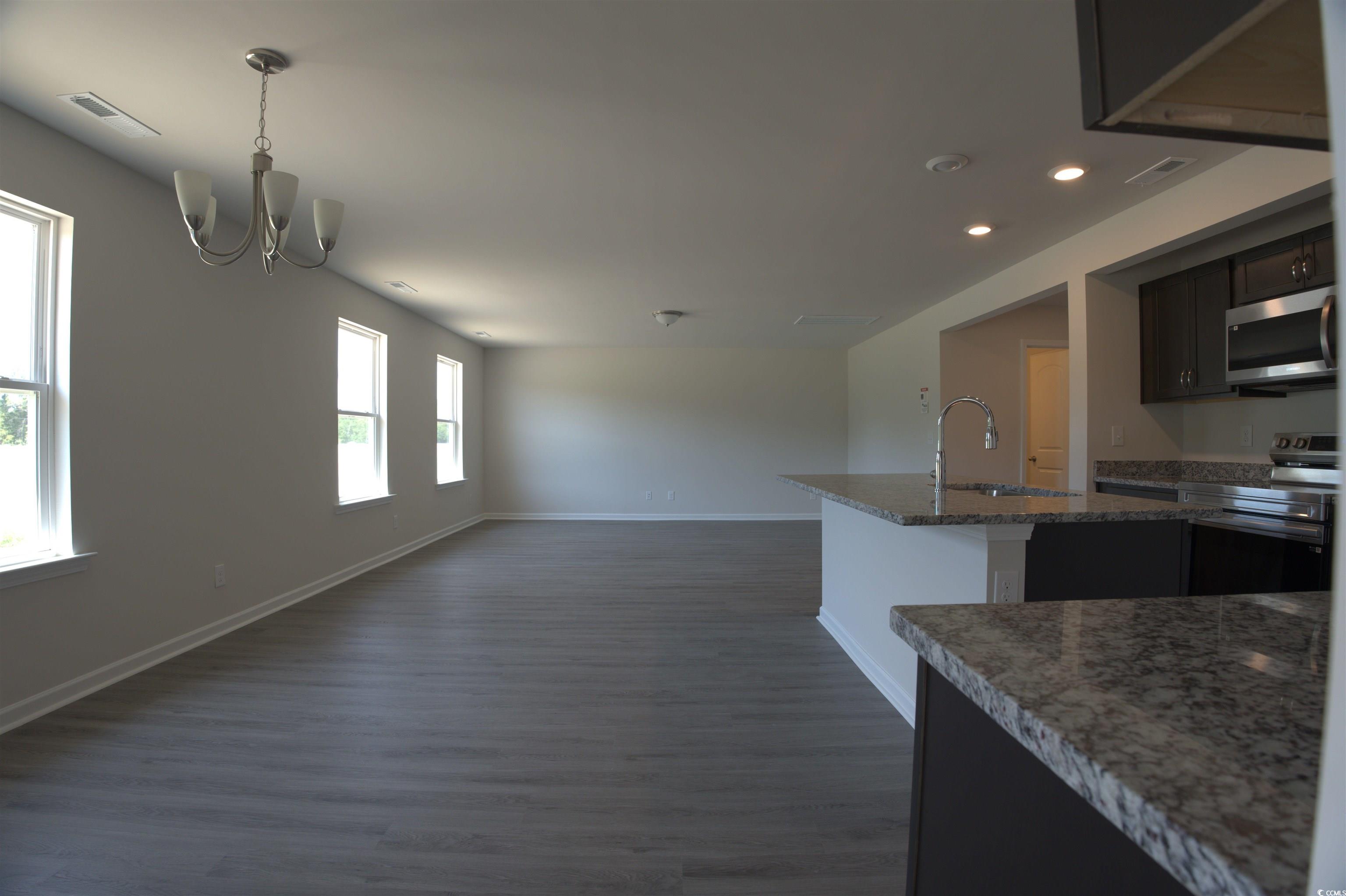 2668 Tansy Road Loris, SC 29569 - Photo 3 of 11 Kitchen with appliances with stainless steel finishes, a chandelier, dark wood-style flooring, light stone counters, and recessed lighting