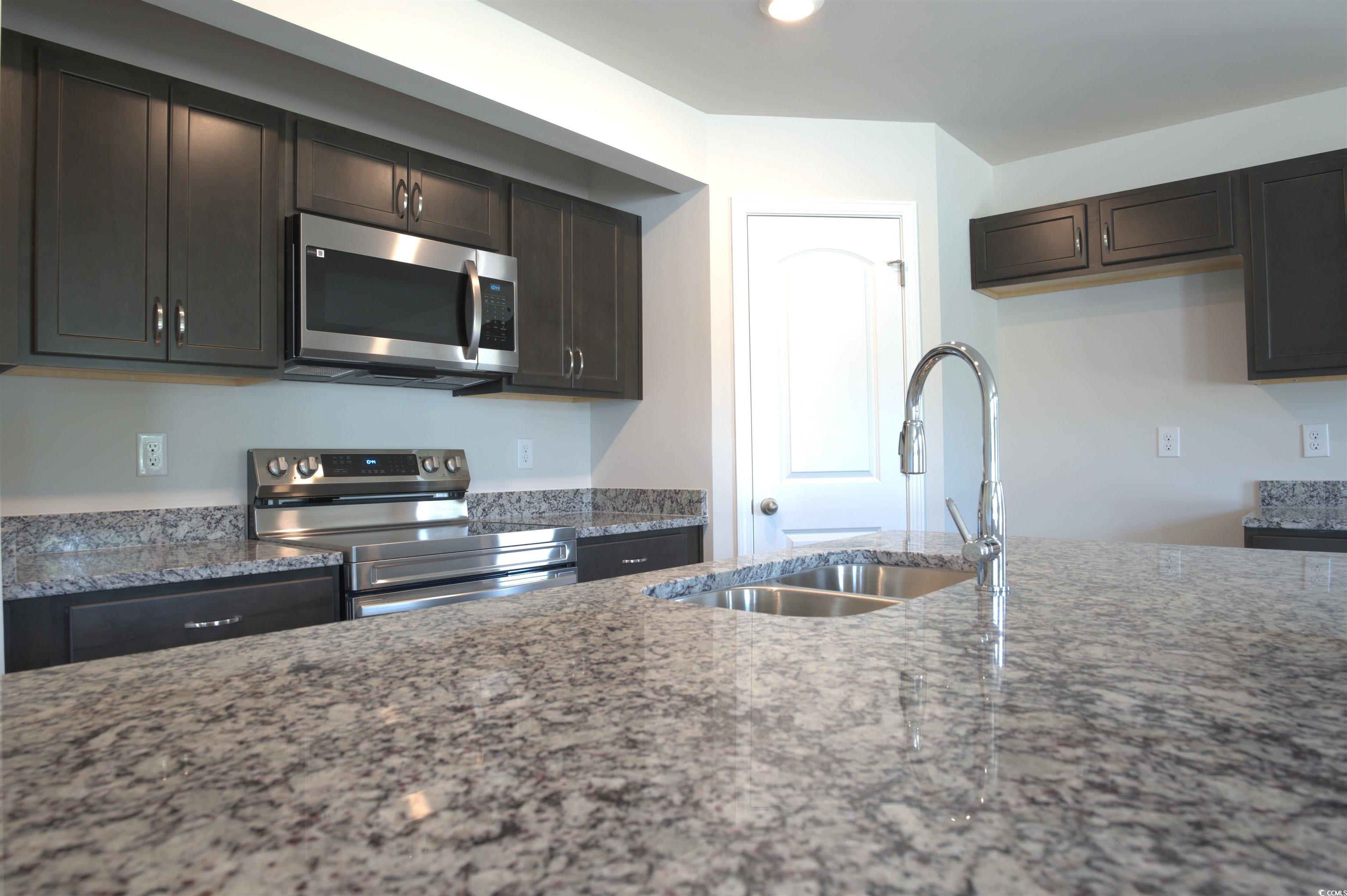 2668 Tansy Road Loris, SC 29569 - Photo 6 of 11 Kitchen with appliances with stainless steel finishes, light stone countertops, dark brown cabinets, and recessed lighting