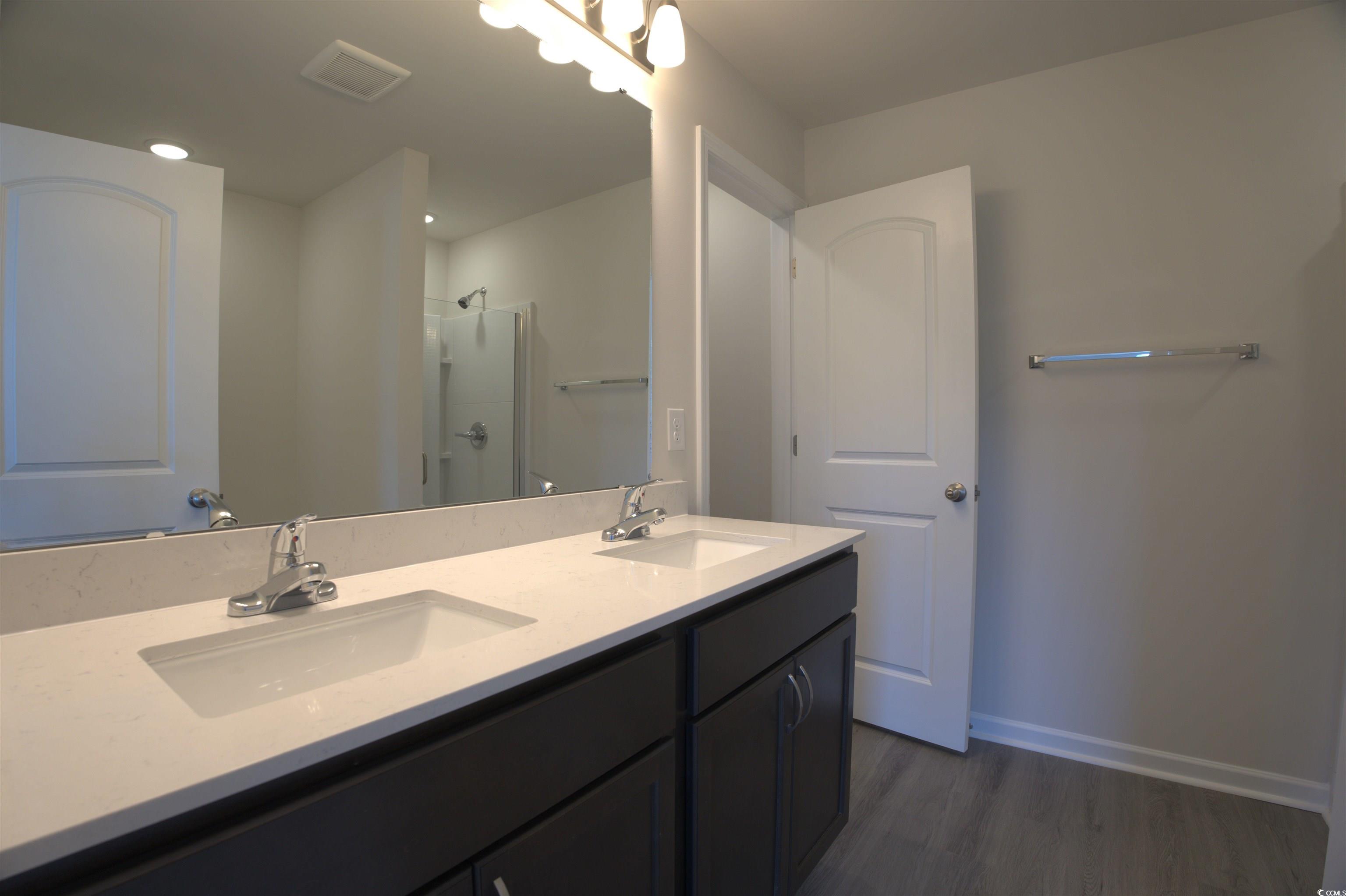 2668 Tansy Road Loris, SC 29569 - Photo 9 of 11 Full bathroom with a stall shower, double vanity, and dark wood-style flooring