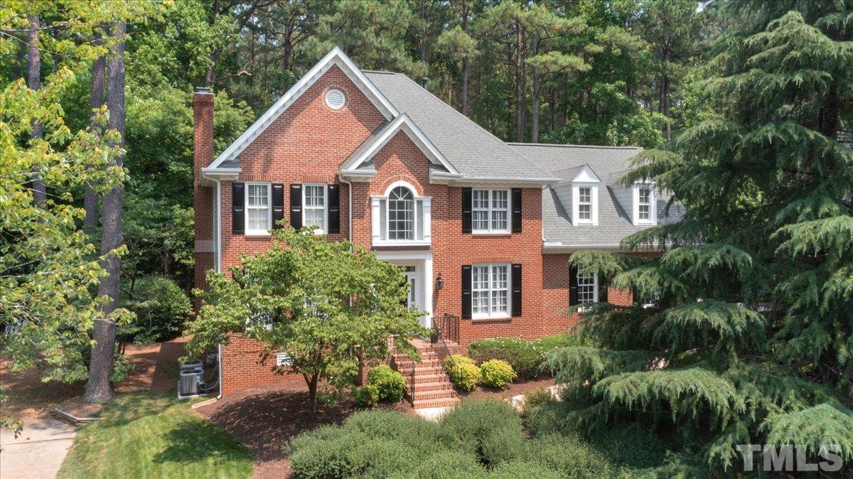 a front view of a house with a yard and plants