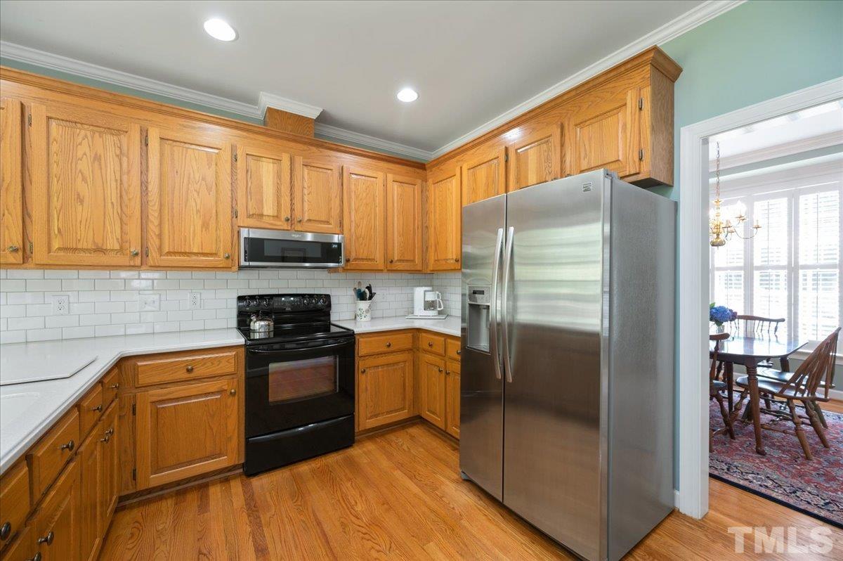 7025 Spring Ridge Road Cary, NC 27518 - Photo 13 of 35 a kitchen with stainless steel appliances granite countertop a refrigerator stove and sink