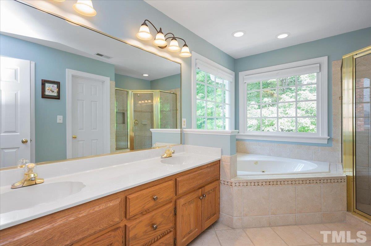 7025 Spring Ridge Road Cary, NC 27518 - Photo 21 of 35 a bathroom with a tub sink and mirror