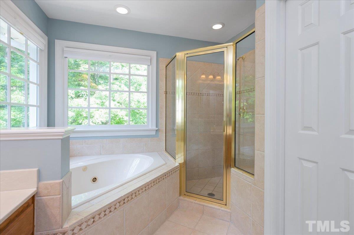 7025 Spring Ridge Road Cary, NC 27518 - Photo 22 of 35 a bathroom with a bathtub and a shower