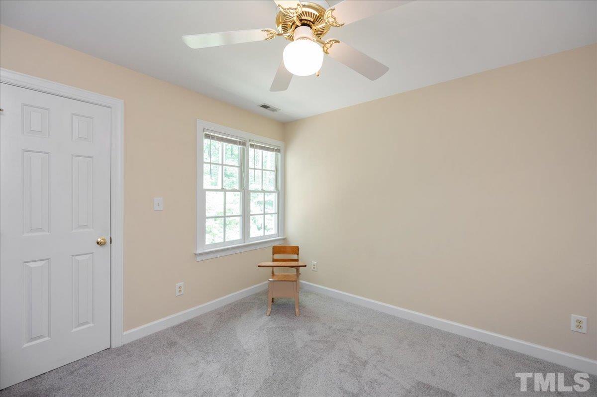 7025 Spring Ridge Road Cary, NC 27518 - Photo 23 of 35 an empty room with a window and a chandelier fan