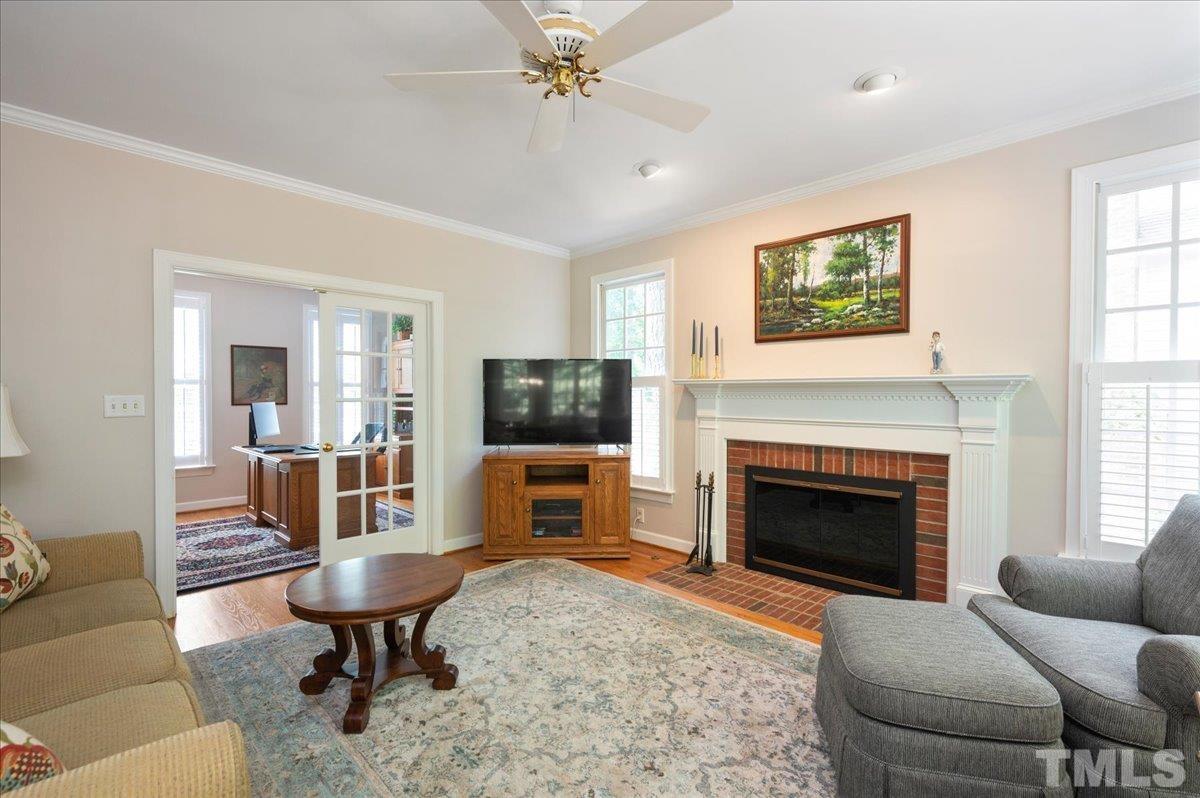 7025 Spring Ridge Road Cary, NC 27518 - Photo 10 of 35 a living room with furniture a fireplace and a flat screen tv