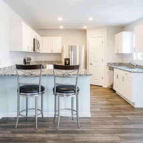 a kitchen with stainless steel appliances granite countertop a stove top oven and refrigerator