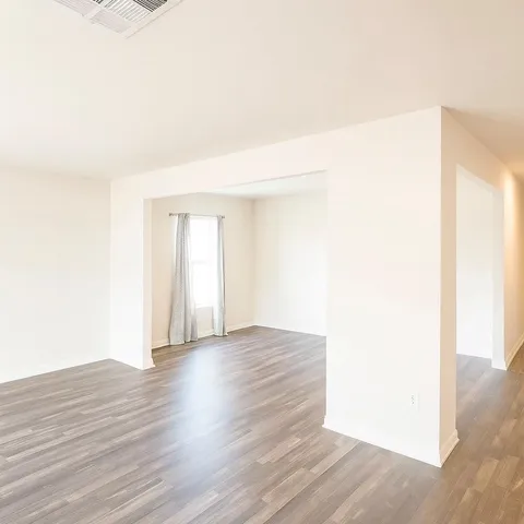 a view of an empty room with wooden floor