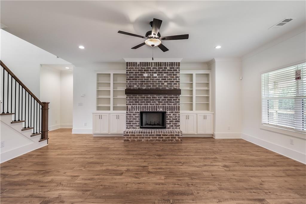 2113 Stonegate Way Monroe, GA 30656 - Photo 21 of 43 a view of a livingroom with a fireplace a ceiling fan and windows