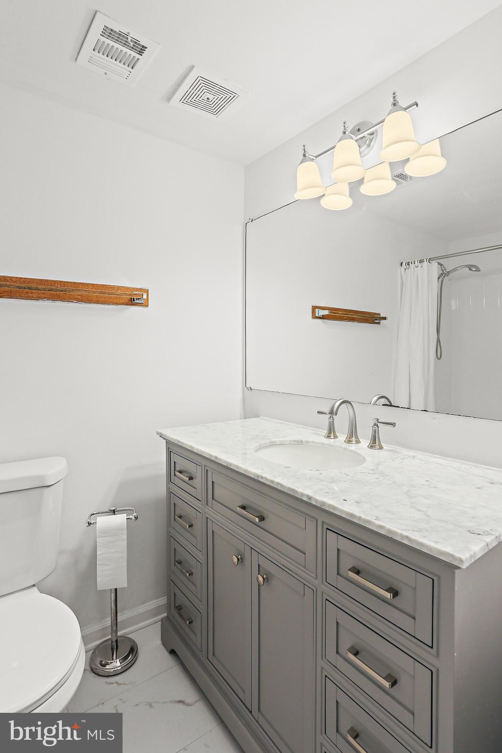 9629 White Acre Road, Unit B2 Columbia, MD 21045 - Photo 7 of 11 a bathroom with a granite countertop sink vanity mirror and toilet