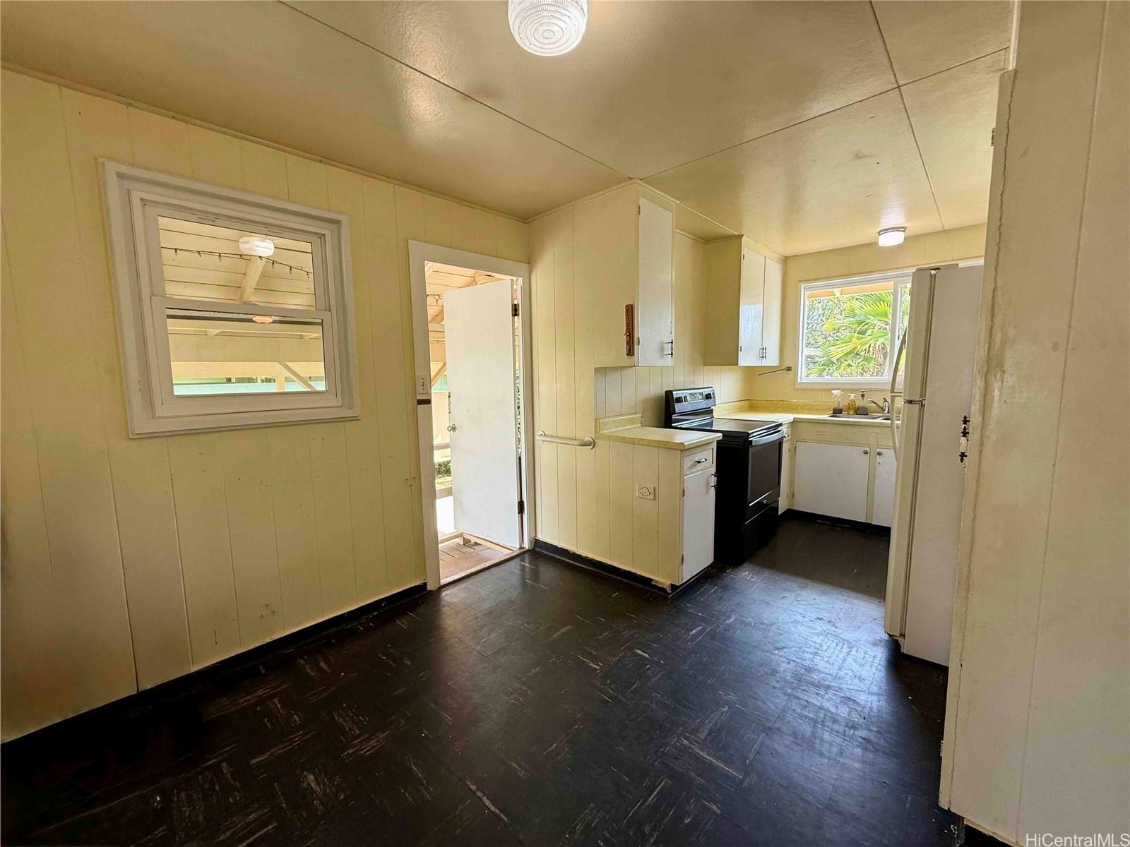 5265 Manauwea Street Honolulu, HI 96821 - Photo 10 of 24 a view of a kitchen with a sink and dishwasher with wooden floor