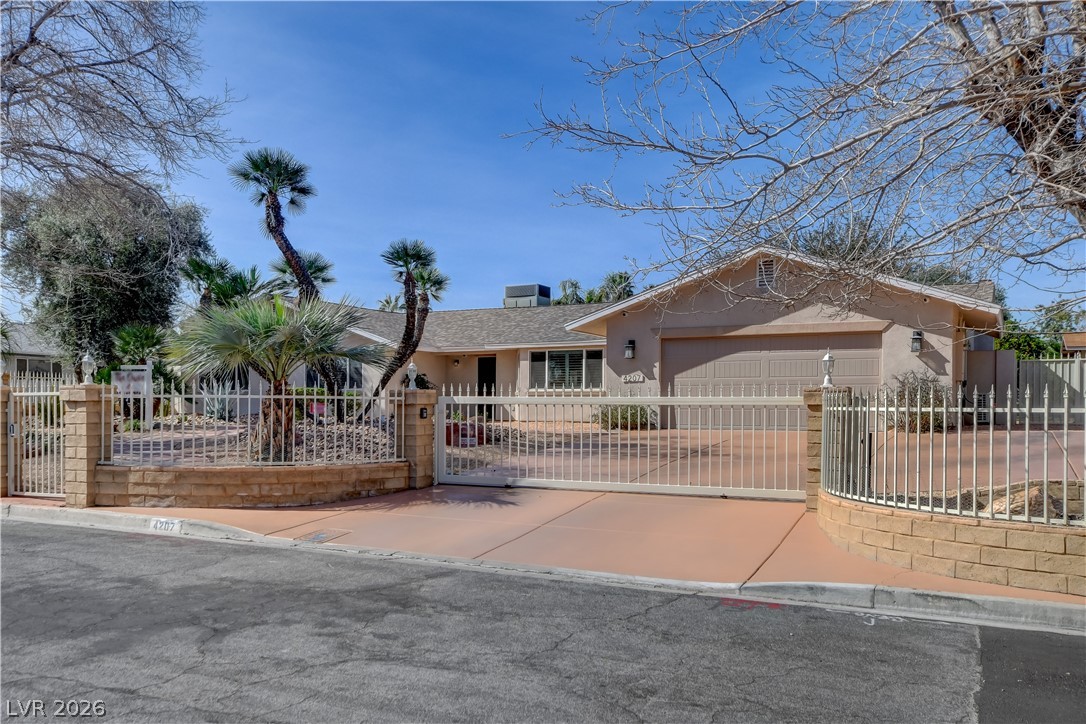 4207 Ridgecrest Drive Las Vegas, NV 89121 - Photo 2 of 27 Ranch-style house featuring a fenced front yard, stucco siding, a garage, and new driveway