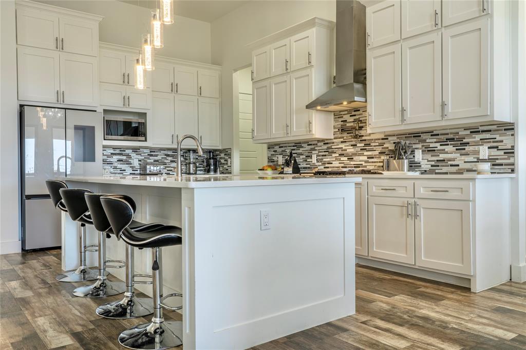 165 Ranch House Road Rockwall, TX 75032 - Photo 11 of 40 a kitchen with kitchen island granite countertop a sink and cabinets