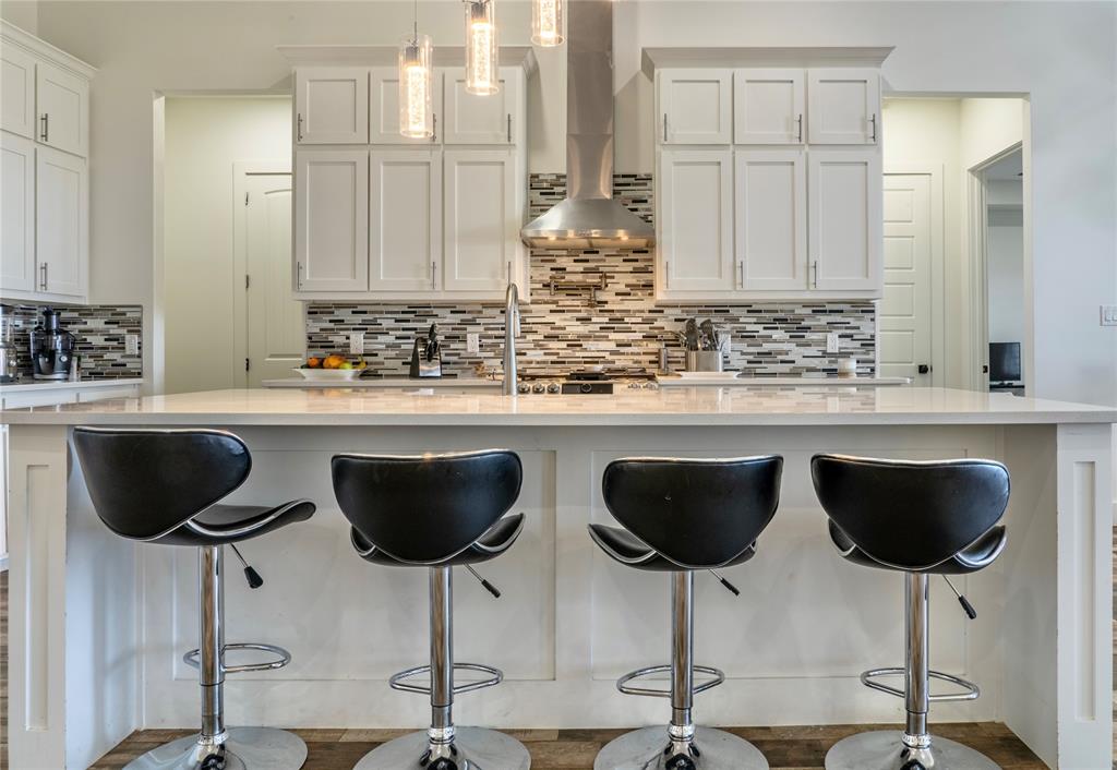 165 Ranch House Road Rockwall, TX 75032 - Photo 12 of 40 a kitchen with a dining table chairs and cabinets