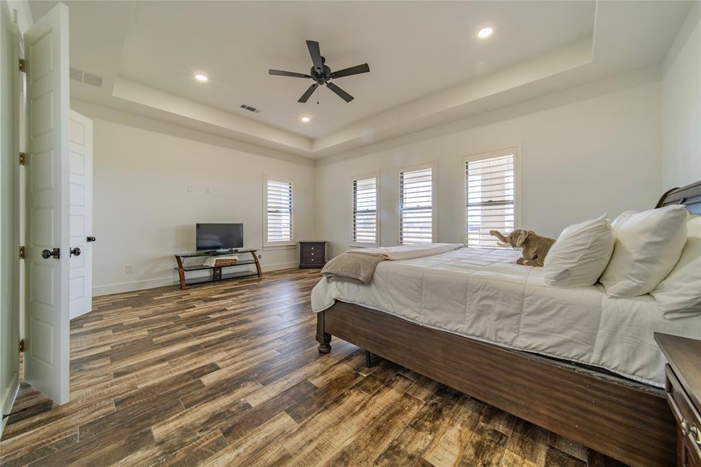 165 Ranch House Road Rockwall, TX 75032 - Photo 27 of 40 a spacious bedroom with a bed a window and a couch