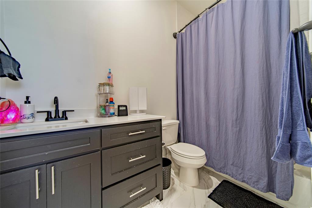 165 Ranch House Road Rockwall, TX 75032 - Photo 35 of 40 a bathroom with a sink a toilet and shower curtain