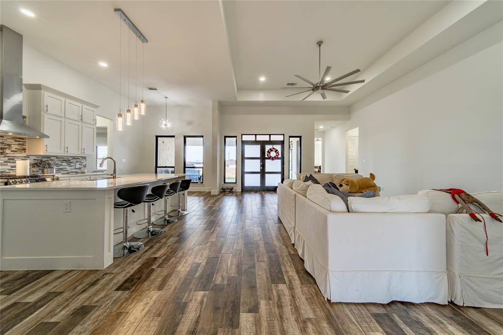 165 Ranch House Road Rockwall, TX 75032 - Photo 9 of 40 a view of a kitchen with kitchen island wooden floors center island and stainless steel appliances